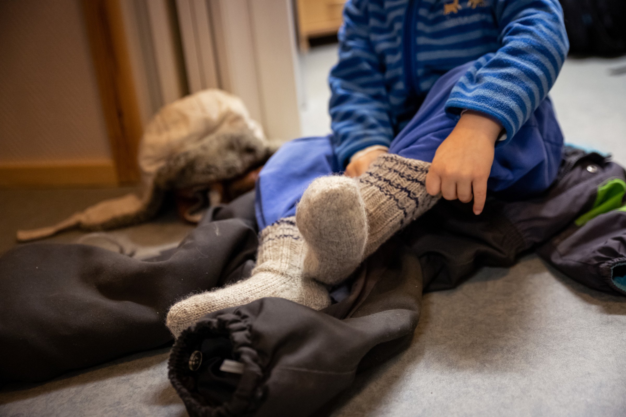 Lapsi laittaa villasukkia jalkaan