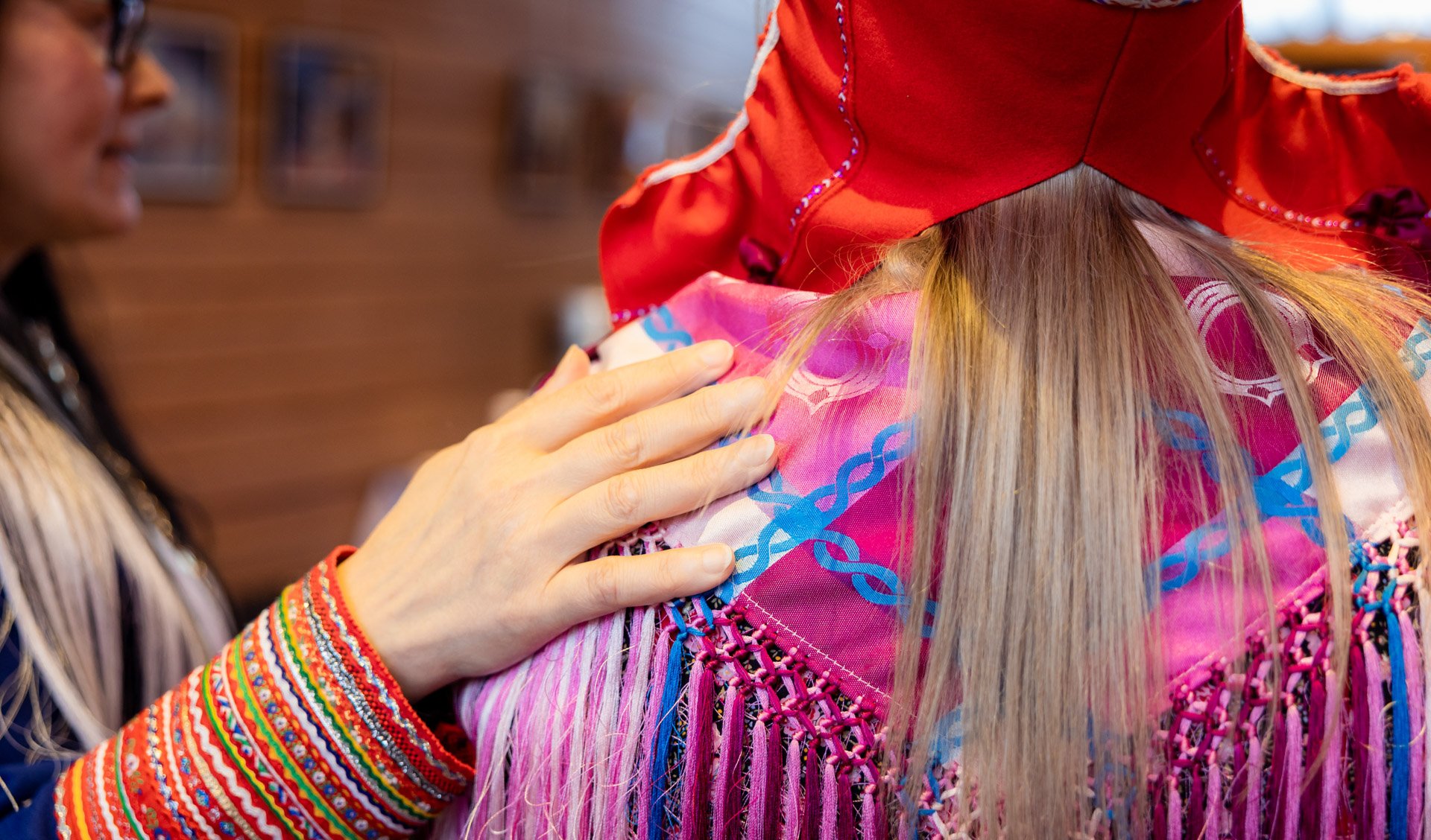 Henkilö pitää kättä toisen henkilön olalla